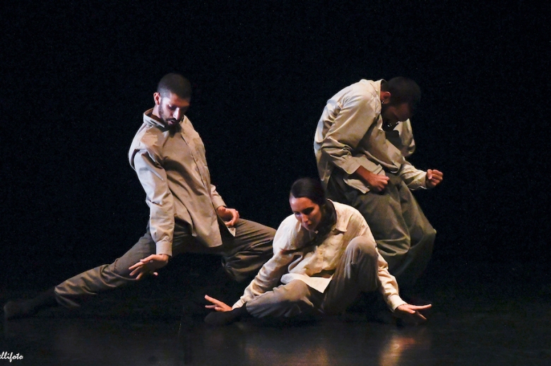 Three dancers on stage in mid-performance